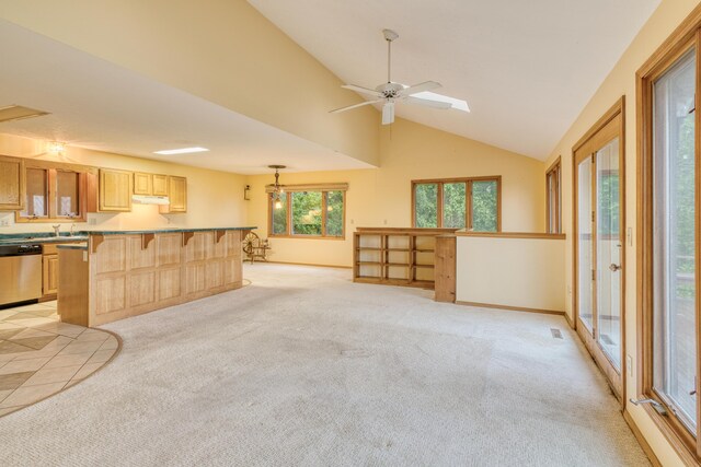 unfurnished living room with a sink, high vaulted ceiling, and light carpet