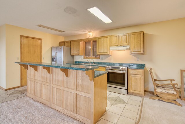 kitchen with a kitchen bar, appliances with stainless steel finishes, light tile patterned floors, light brown cabinets, and under cabinet range hood