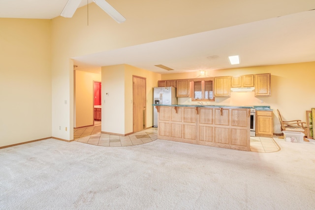 unfurnished living room with baseboards, ceiling fan, and light carpet