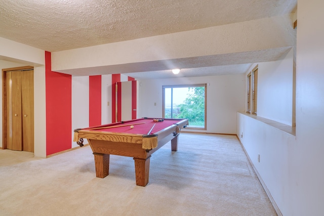 rec room with pool table, a textured ceiling, light carpet, and baseboards