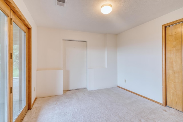 carpeted spare room with visible vents and baseboards