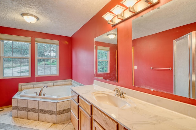 full bathroom featuring a bath, tile patterned floors, vanity, and a textured ceiling
