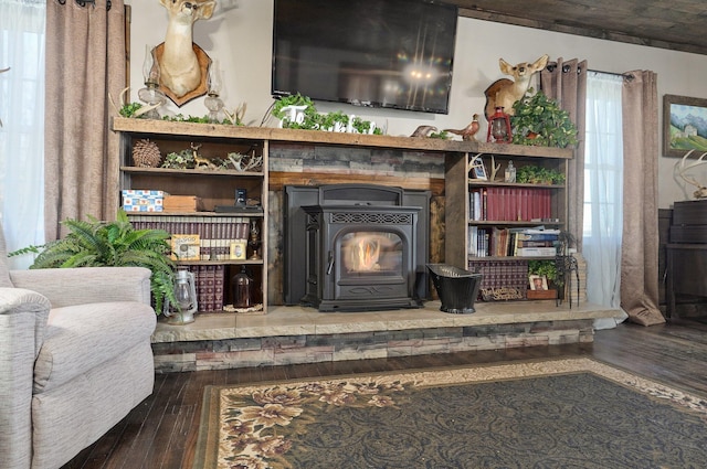 living area with wood-type flooring and a wood stove