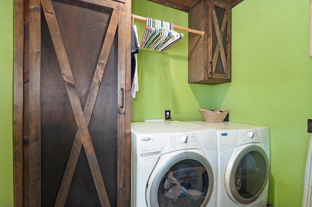 laundry room featuring washing machine and clothes dryer and cabinet space