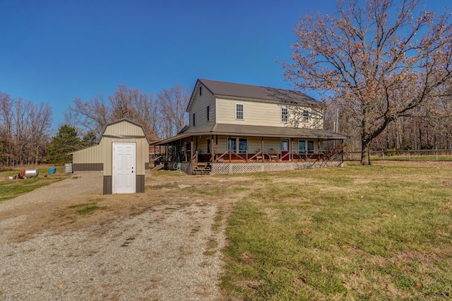 view of home's exterior with a storage unit, a porch, an outbuilding, a lawn, and metal roof