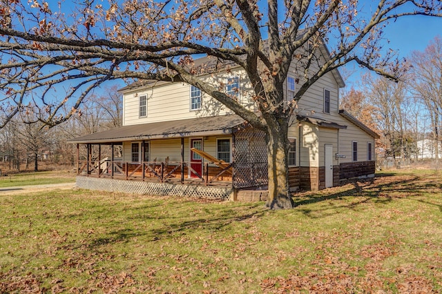 exterior space featuring covered porch, metal roof, a front lawn, and stone siding