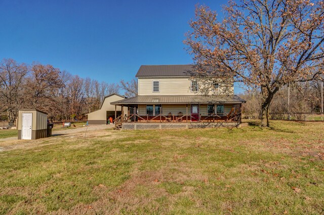 rear view of house with a storage shed, a deck, a lawn, an outdoor structure, and metal roof