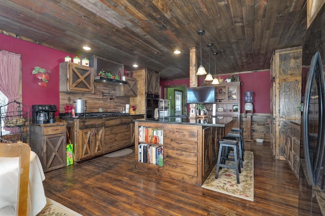 kitchen featuring a kitchen island with sink, dark countertops, wooden ceiling, black appliances, and dark wood-style floors