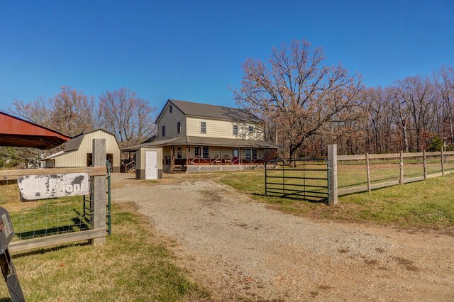 view of front of house with fence, an outdoor structure, a front lawn, and a shed