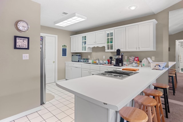 161 Avondale Dr Unit 11, Branson, MO 65616 - kitchen with baseboards, white cabinets, a peninsula, stainless steel electric cooktop, and a breakfast bar