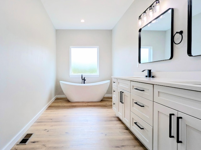 3875 E Dehaven Ln, Fair Grove, MO 65648 - bathroom with double vanity, wood finished floors, a soaking tub, and recessed lighting