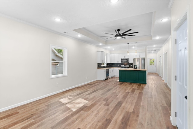 1626 W Lee St, Springfield, MO 65803 - kitchen with ceiling fan, crown molding, appliances with stainless steel finishes, white cabinets, and a tray ceiling