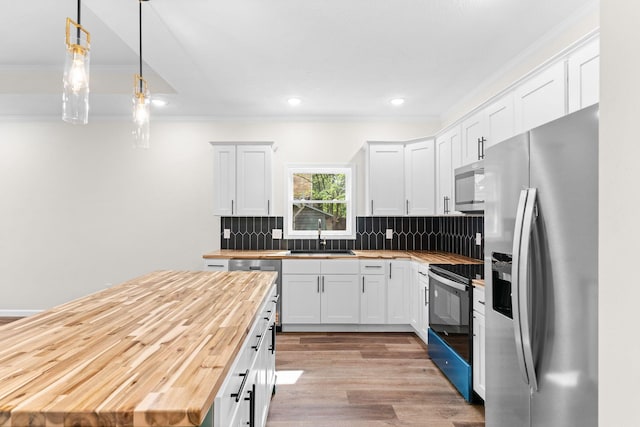1626 W Lee St, Springfield, MO 65803 - kitchen with a sink, ornamental molding, stainless steel appliances, and butcher block counters