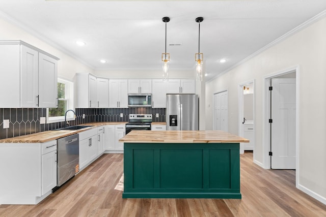 1626 W Lee St, Springfield, MO 65803 - kitchen featuring a sink, wood counters, ornamental molding, stainless steel appliances, and white cabinetry