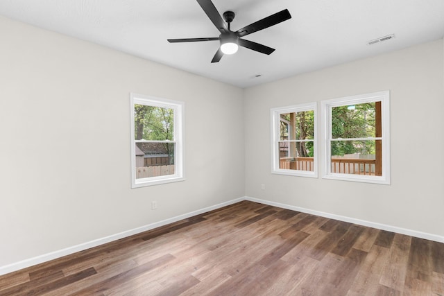 1626 W Lee St, Springfield, MO 65803 - unfurnished room with a healthy amount of sunlight, baseboards, wood finished floors, and visible vents