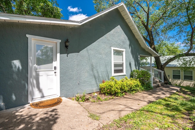 view of exterior entry featuring stucco siding