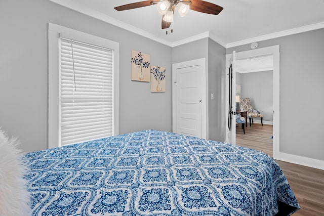 bedroom with baseboards, ceiling fan, ornamental molding, and wood finished floors