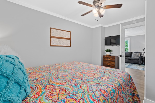 bedroom featuring ornamental molding, a ceiling fan, and wood finished floors