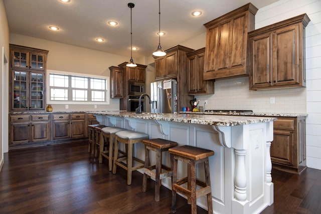 1770 Logan Ridge Rd, Ozark, MO 65721 - kitchen with dark wood-style floors, stainless steel appliances, a kitchen bar, tasteful backsplash, and a center island with sink