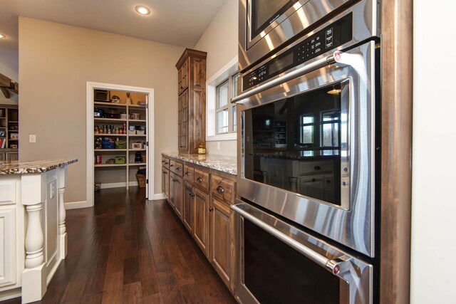 1770 Logan Ridge Rd, Ozark, MO 65721 - kitchen with light stone counters, double oven, dark wood finished floors, brown cabinetry, and recessed lighting