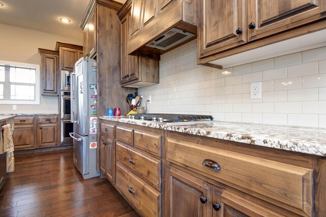 1770 Logan Ridge Rd, Ozark, MO 65721 - kitchen with appliances with stainless steel finishes, backsplash, brown cabinets, and light stone countertops