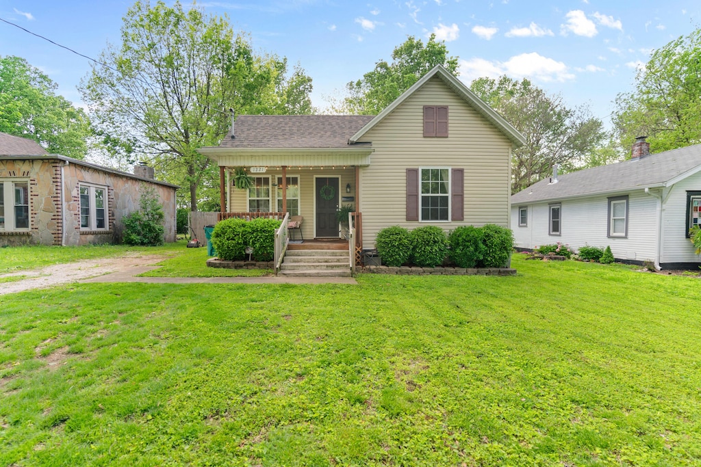 bungalow with covered porch and a front yard