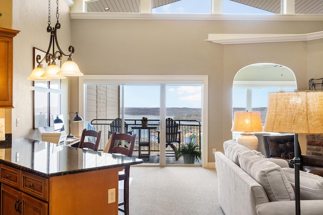kitchen featuring a breakfast bar area, carpet flooring, brown cabinets, and open floor plan