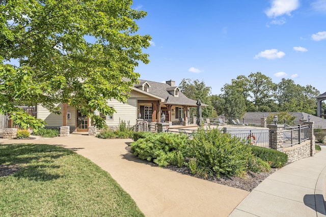 view of front facade with fence, a chimney, and a front yard