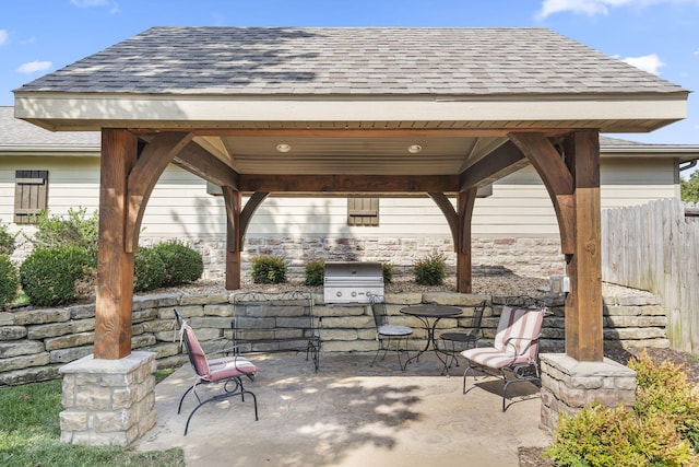 view of patio featuring grilling area, exterior kitchen, a gazebo, and fence