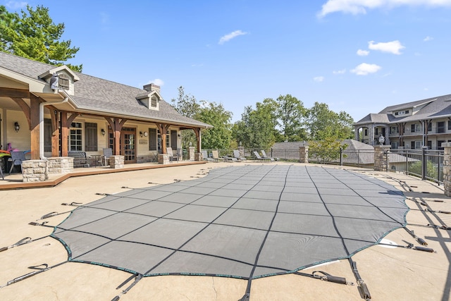 community pool featuring fence and a patio area