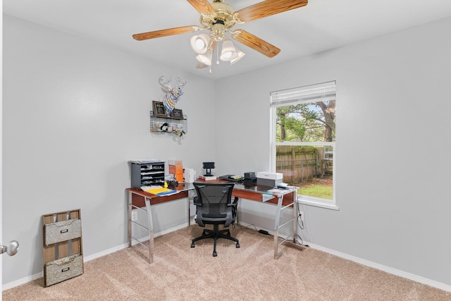carpeted office with baseboards and a ceiling fan