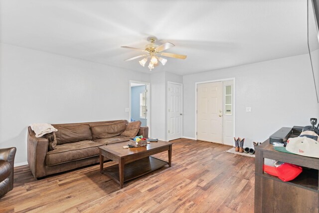 living room with baseboards, light wood finished floors, and ceiling fan