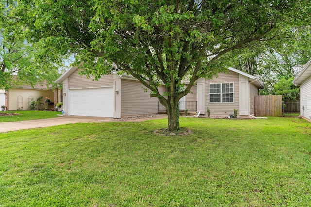 view of property hidden behind natural elements featuring a front lawn, fence, and concrete driveway