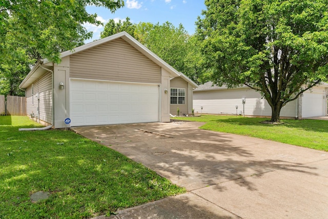 view of front of home with fence, a front yard, and a garage