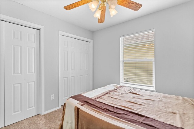 bedroom with a ceiling fan, baseboards, and light carpet