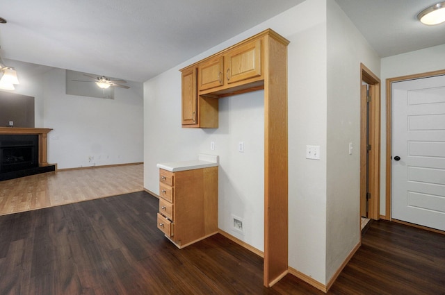kitchen featuring baseboards, a ceiling fan, dark wood-style flooring, and light countertops
