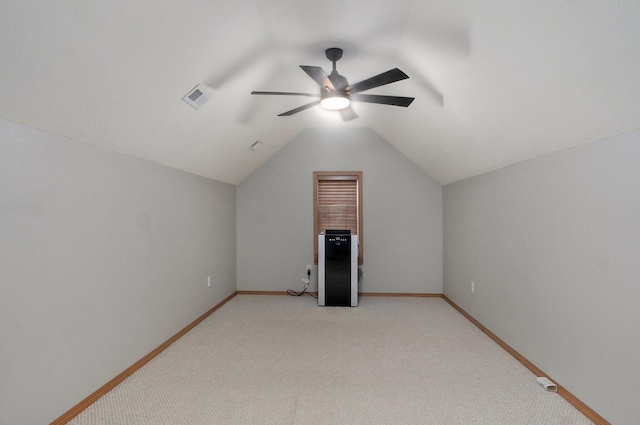 additional living space featuring visible vents, lofted ceiling, baseboards, light colored carpet, and a ceiling fan