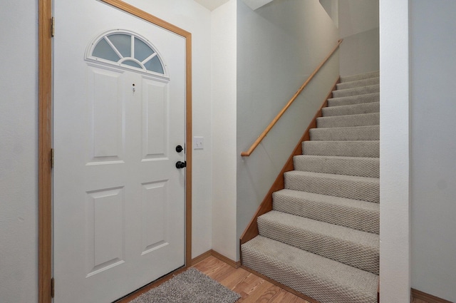 foyer entrance featuring stairs and light wood-style flooring