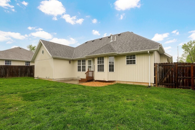 back of property with a fenced backyard, a yard, a gate, and a shingled roof