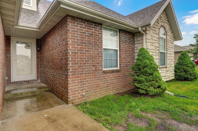 view of side of property with a shingled roof and brick siding
