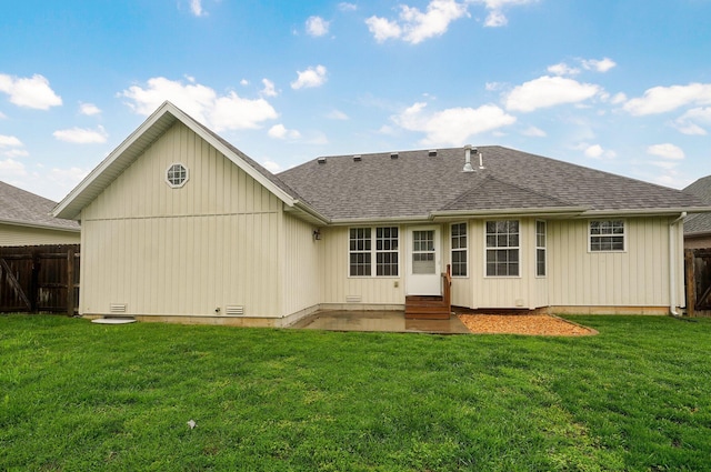 rear view of house with a lawn, fence, and entry steps