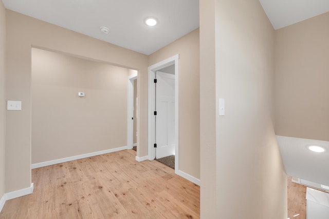 corridor with light wood-style floors, recessed lighting, and baseboards