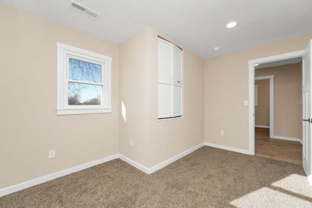 carpeted spare room featuring baseboards, recessed lighting, and visible vents