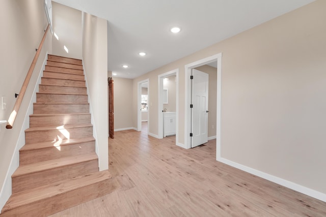 stairs with recessed lighting, baseboards, and wood finished floors
