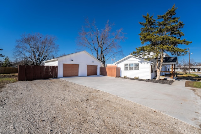 view of side of home featuring a garage, fence, and an outdoor structure