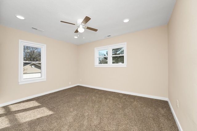 unfurnished room featuring visible vents, baseboards, carpet floors, and ceiling fan