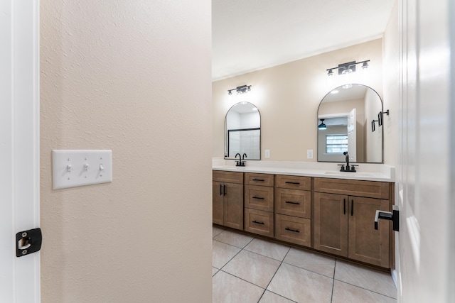 bathroom with double vanity, ceiling fan, a sink, and tile patterned flooring