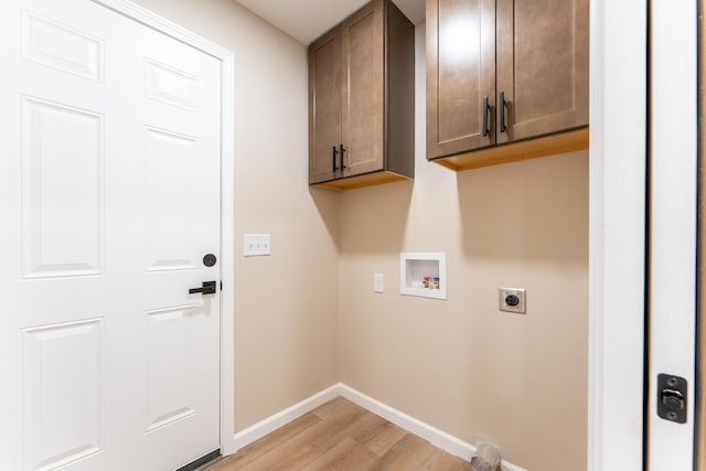 clothes washing area with hookup for an electric dryer, light wood-type flooring, cabinet space, baseboards, and hookup for a washing machine