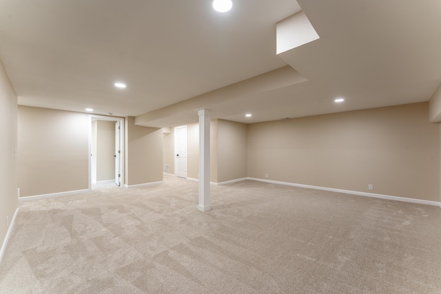 finished basement featuring light colored carpet, recessed lighting, and baseboards