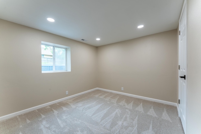empty room featuring light colored carpet, recessed lighting, baseboards, and visible vents